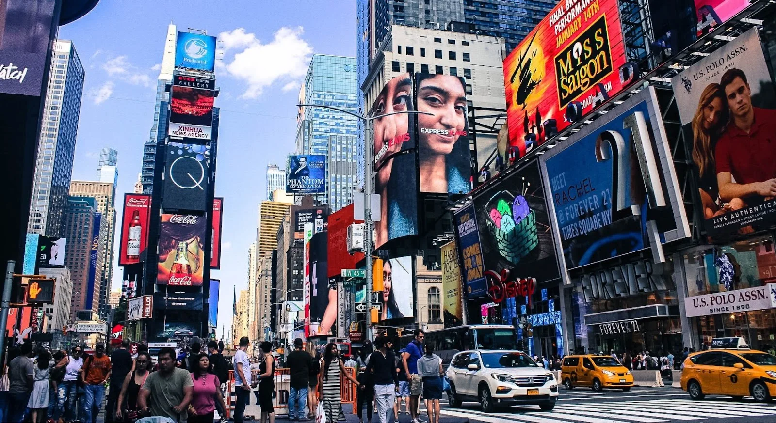Bustling Times Square with towering digital billboards and yellow taxis, showcasing New York City as a luxury travel destination