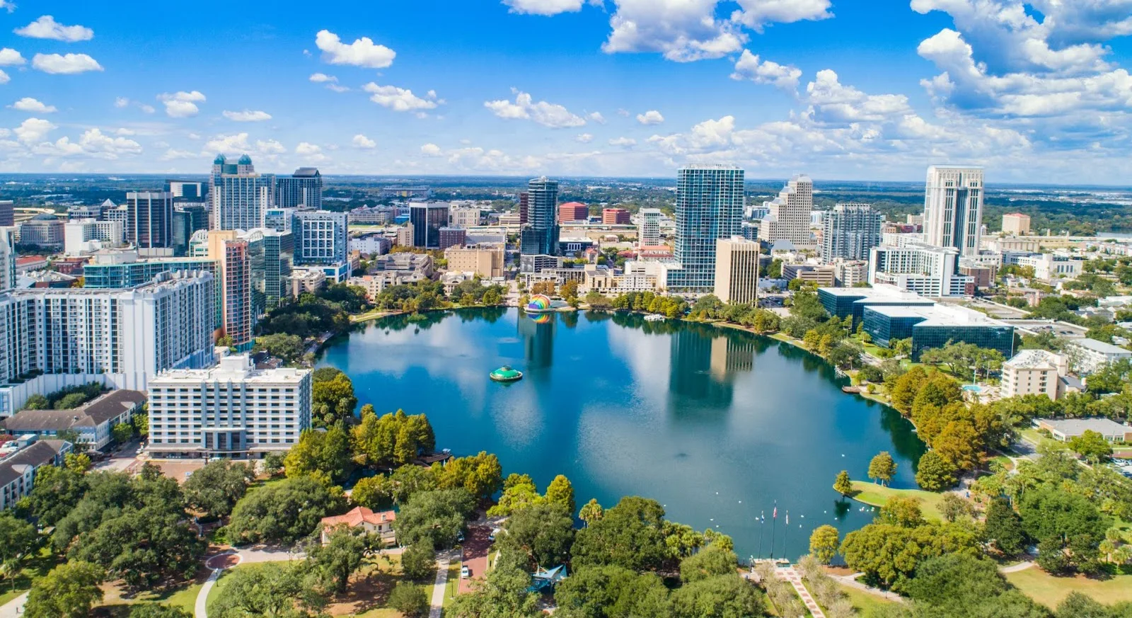 Aerial view of Orlando downtown skyline with Lake Eola reflecting modern skyscrapers and lush parks