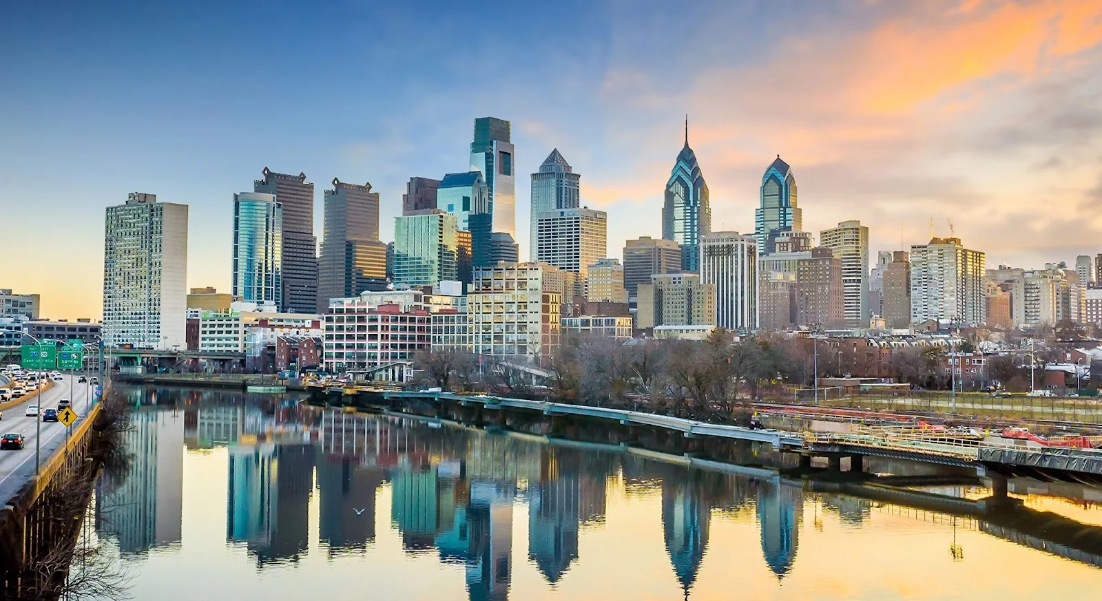 Philadelphia skyline at sunset with Schuylkill River reflections showcasing departure city for Phoenix empty leg flights