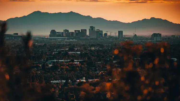 Phoenix skyline at sunset with mountains backdrop showcasing luxury travel destination for private jet charters