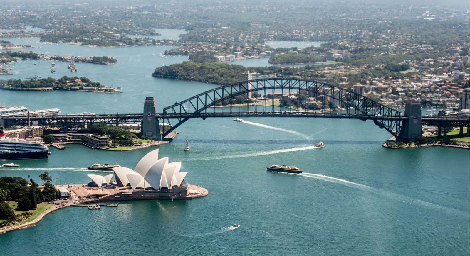 Aerial view of Sydney Harbour showcasing Opera House and Harbour Bridge, premier destination for luxury jet travel