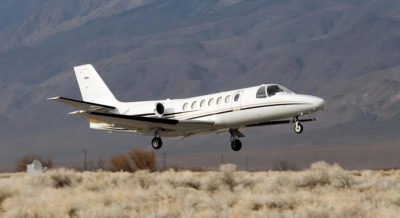 White Citation CJ2 private jet landing on desert runway showcasing empty leg charter opportunities