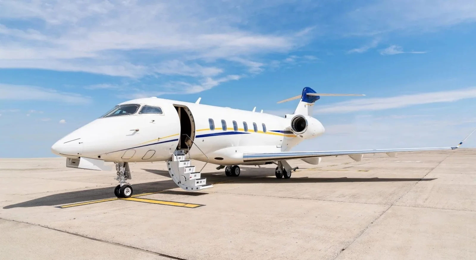White private jet with boarding stairs deployed on tarmac, ready for empty leg charter flight departure