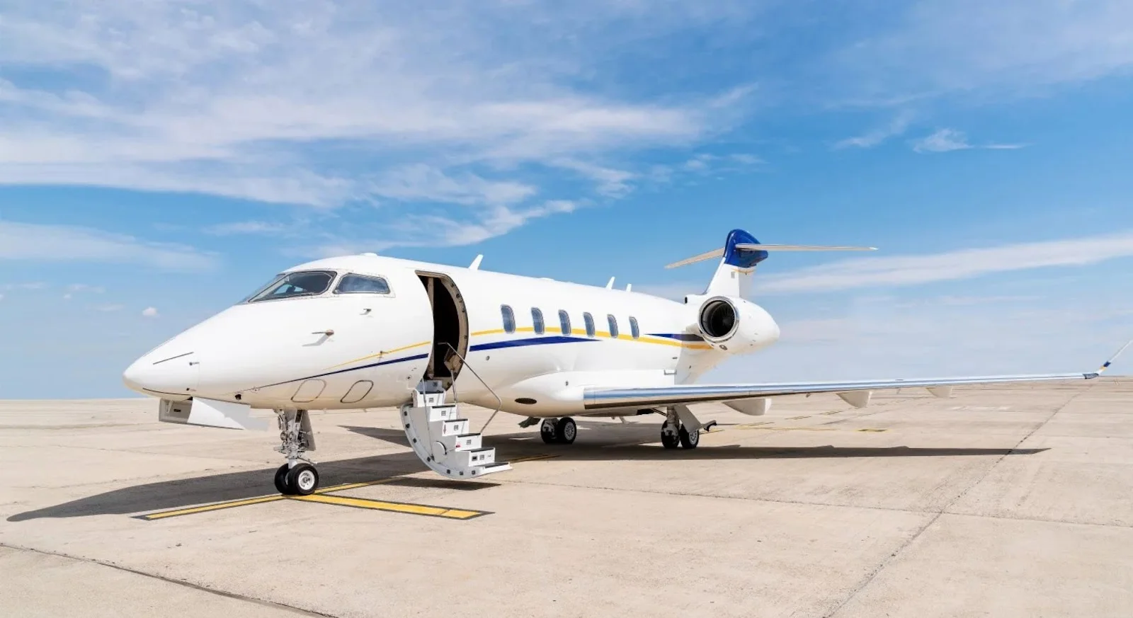White luxury private jet with open cabin door parked on tarmac, ready for empty leg charter flight