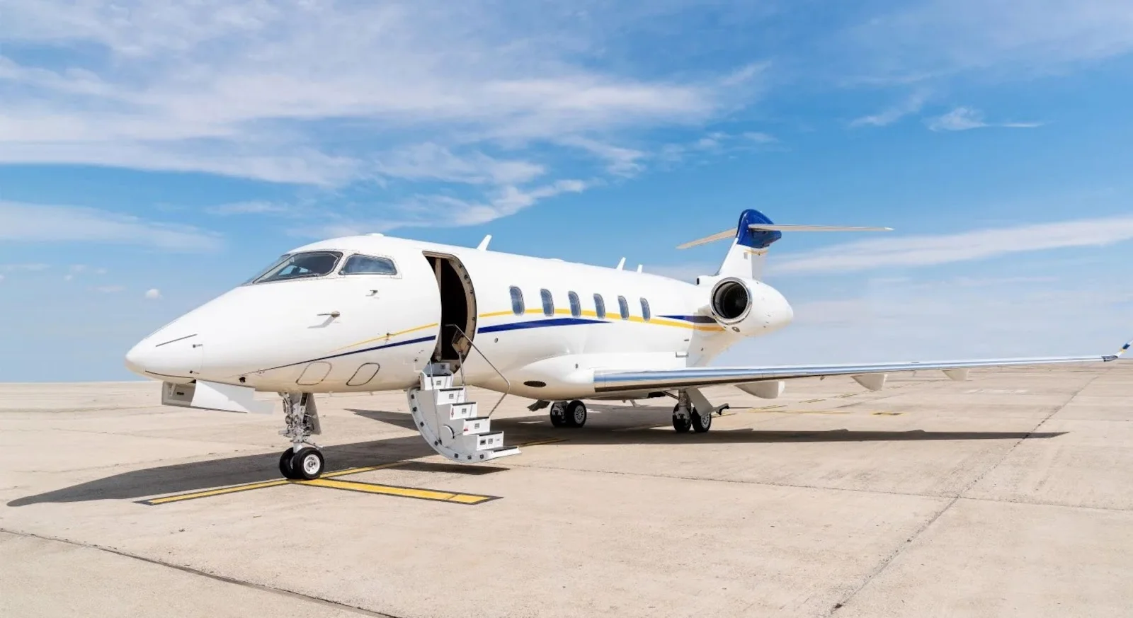White private jet with open cabin door parked on tarmac, ready for empty leg charter flight departure