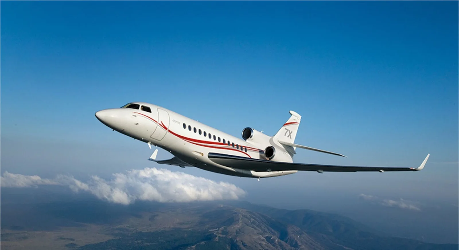 White private jet with red accent stripes cruising above clouds, showcasing luxury aircraft for empty leg charter flights