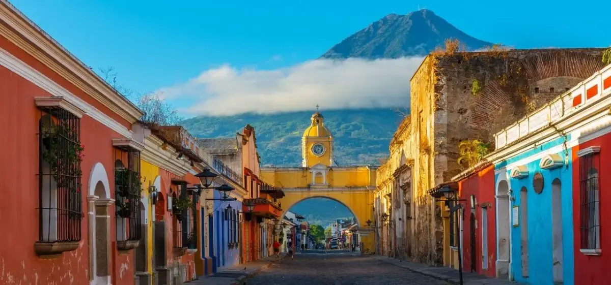 Colonial street in Antigua Guatemala with volcano landscape in the background