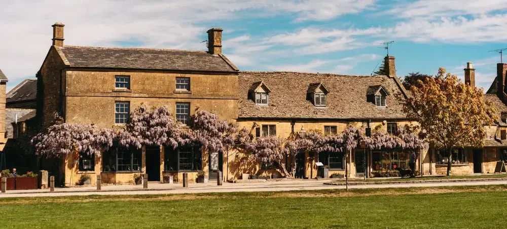 Cotswolds village facade draped in flowering wisteria, an English countryside destination accessible by private jet charter