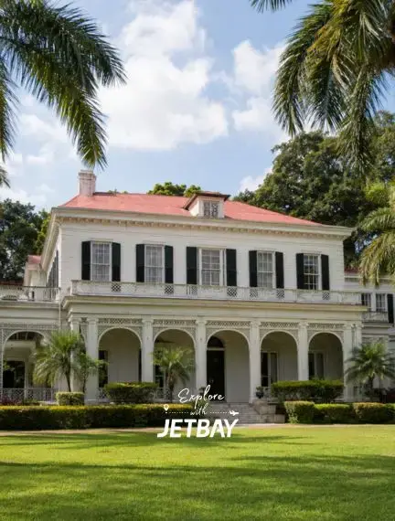 Devon House historic colonial mansion in Kingston, Jamaica, surrounded by palm trees and manicured lawns on a sunny day