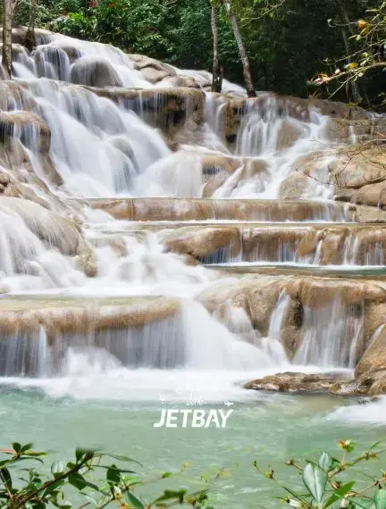 Tiered cascades of Dunn's River Falls in Ocho Rios, Jamaica, a top luxury destination accessible by private jet charter