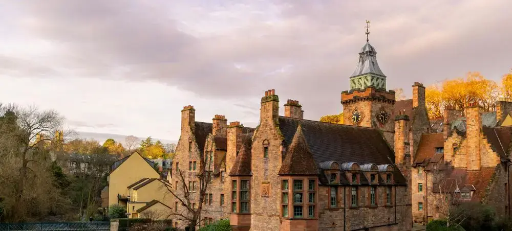 Historic sandstone buildings with a clock tower in Edinburgh's Dean Village