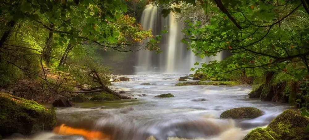 Secluded waterfall with a rocky river in Eryri, Snowdonia, a natural landmark accessible via private jet to North Wales