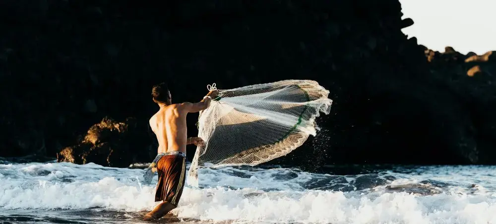 Fisherman casting net on El Salvador beach