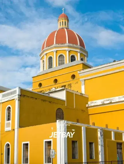Granada Cathedral's iconic terracotta dome rising above vivid yellow colonial façade in Granada, Nicaragua