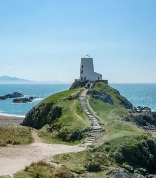 Tŵr Mawr lighthouse on Llanddwyn Island, Anglesey, a scenic coastal landmark accessible when flying private to Wales