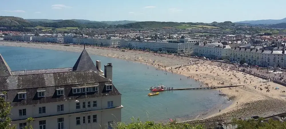 Aerial view of Llandudno's sweeping sandy bay and Victorian promenade, a coastal destination accessible by private jet