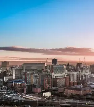 Aerial sunset view of Manchester city centre skyline, a premier private jet charter destination in the UK