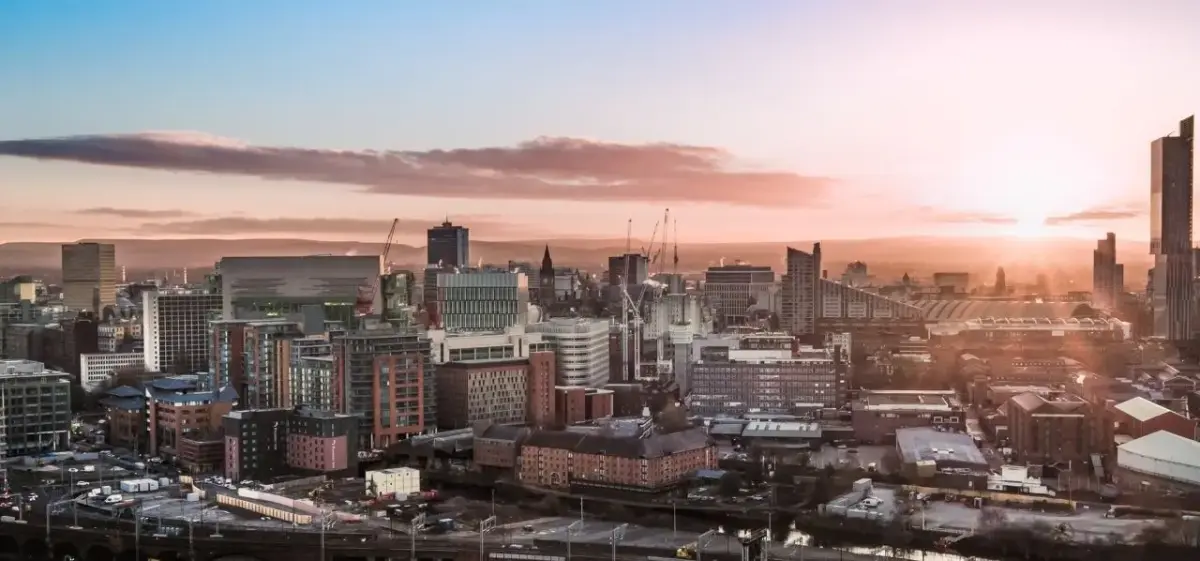 Aerial panoramic view of Manchester city centre skyline at dusk, showcasing the urban landscape for private jet travellers