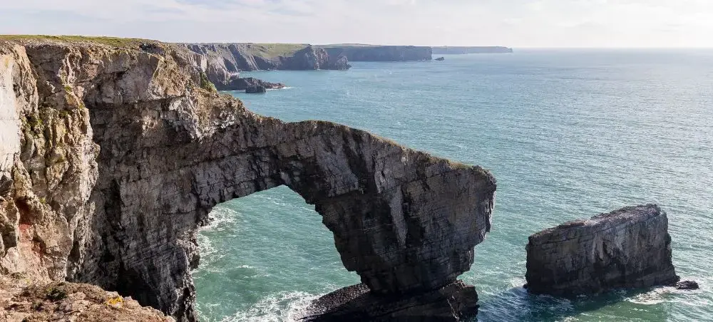 Coastal rock arch at the Green Bridge of Wales, Pembrokeshire, a breathtaking destination accessible by private jet charter