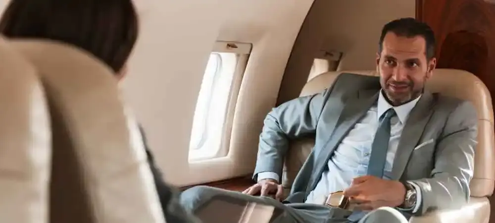 Business executive in a tailored suit relaxing in a luxury private jet cabin en route to England