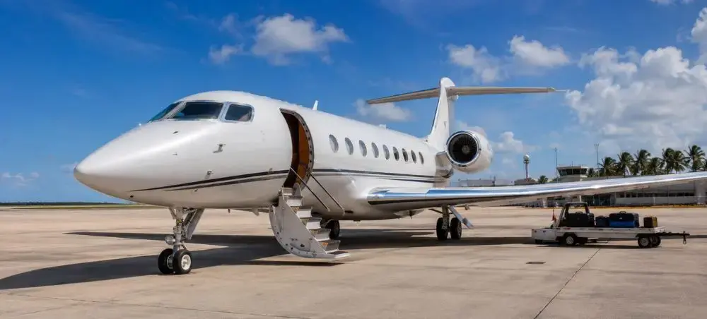 Gulfstream private jet with boarding stairs deployed on a sunny Barbados tarmac, ready for departure amid tropical skies