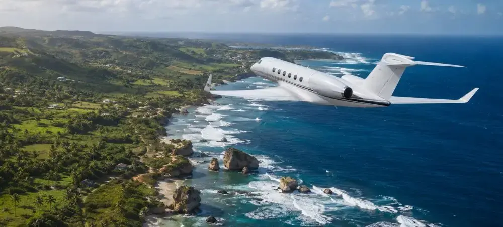Private jet flying above the rugged east coast of Barbados near Bathsheba