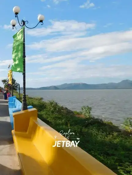 Scenic waterfront promenade at Puerto Salvador Allende in Managua, Nicaragua, with colorful yellow barriers, green flags, and views across Lake Managua toward distant mountains