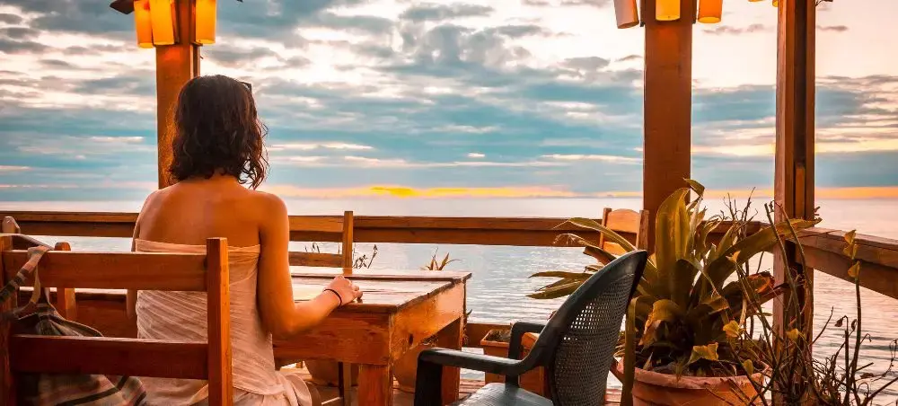 A young woman in a West End restaurant on Roatan Island during sunset