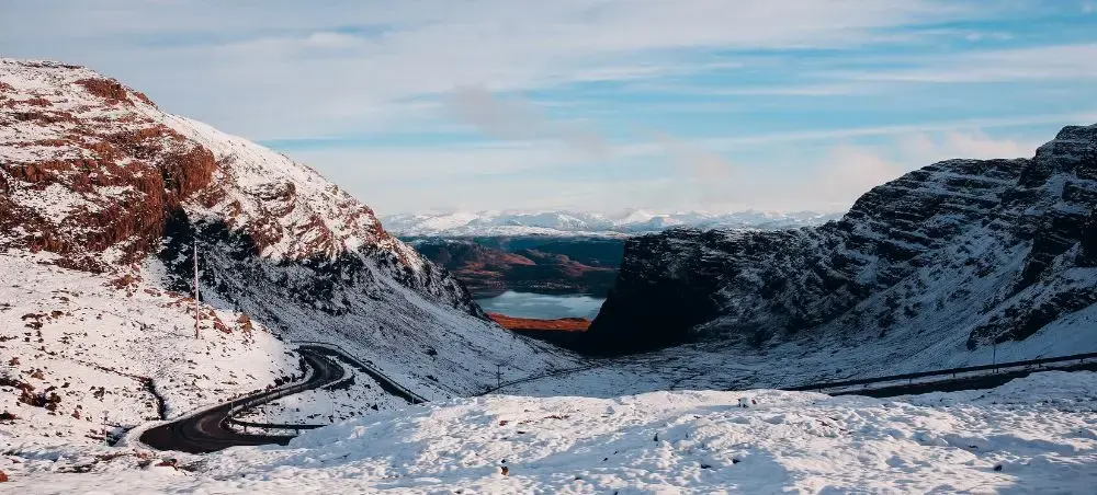 Snow-dusted Highland mountain pass framed by rugged peaks, a gateway accessible by private jet charter to the Scotland