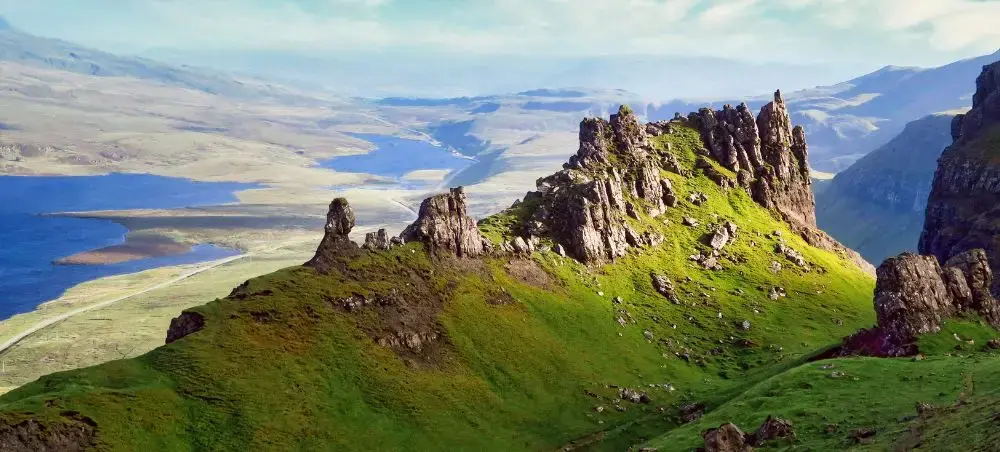 Rocky pinnacles and vivid green hillsides of the Scottish Highlands overlooking a remote loch, accessible by private jet