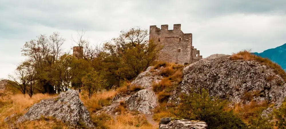 The ruins of Tourbillon Castle in Switzerland located on a hill with Valere basilica in the background
