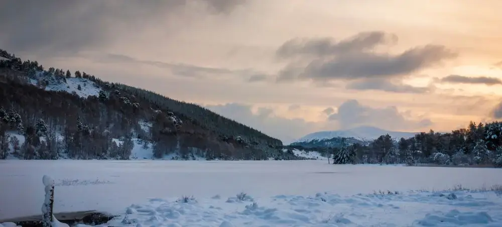 Snow-covered Speyside valley at dusk with hills and mountain backdrop, a Scottish destination accessible by private jet