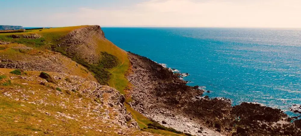 Welsh coastal cliffs with headland, shores and sea, reflecting Wales' rugged landscapes accessible by private jet charter