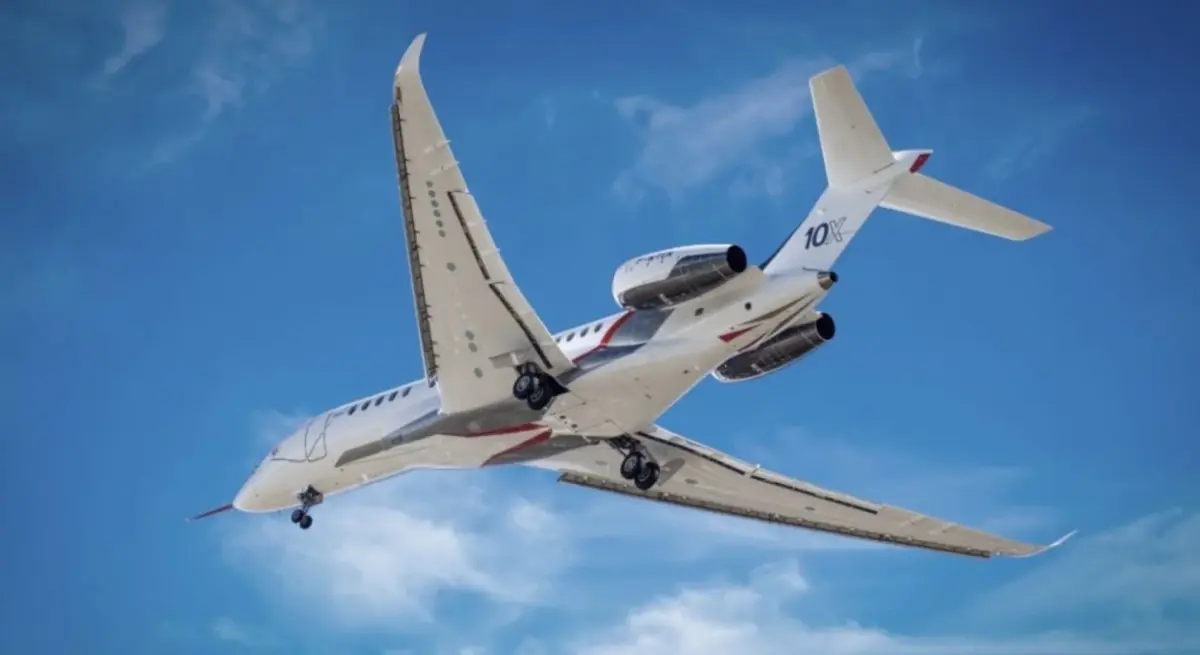 Dassault Falcon 10X ultra-long-range private jet in flight against blue sky, available for charter through Jetbay
