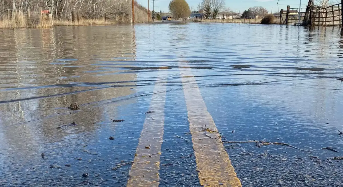 Flooded rural road submerged under rising floodwaters, illustrating why private jet charter is essential for flood emergency evacuations