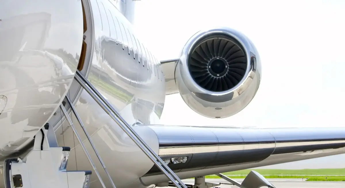 Bombardier Global 7500 private jet on the tarmac with open boarding stairs and polished turbofan engine up close