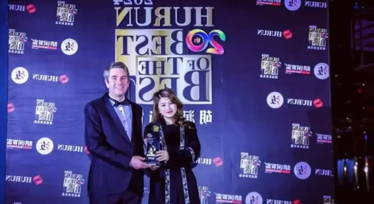 Jetbay founder Vivian Zhang celebrates with a crystal trophy at the Hurun Best of the Best Private Aviation Awards ceremony