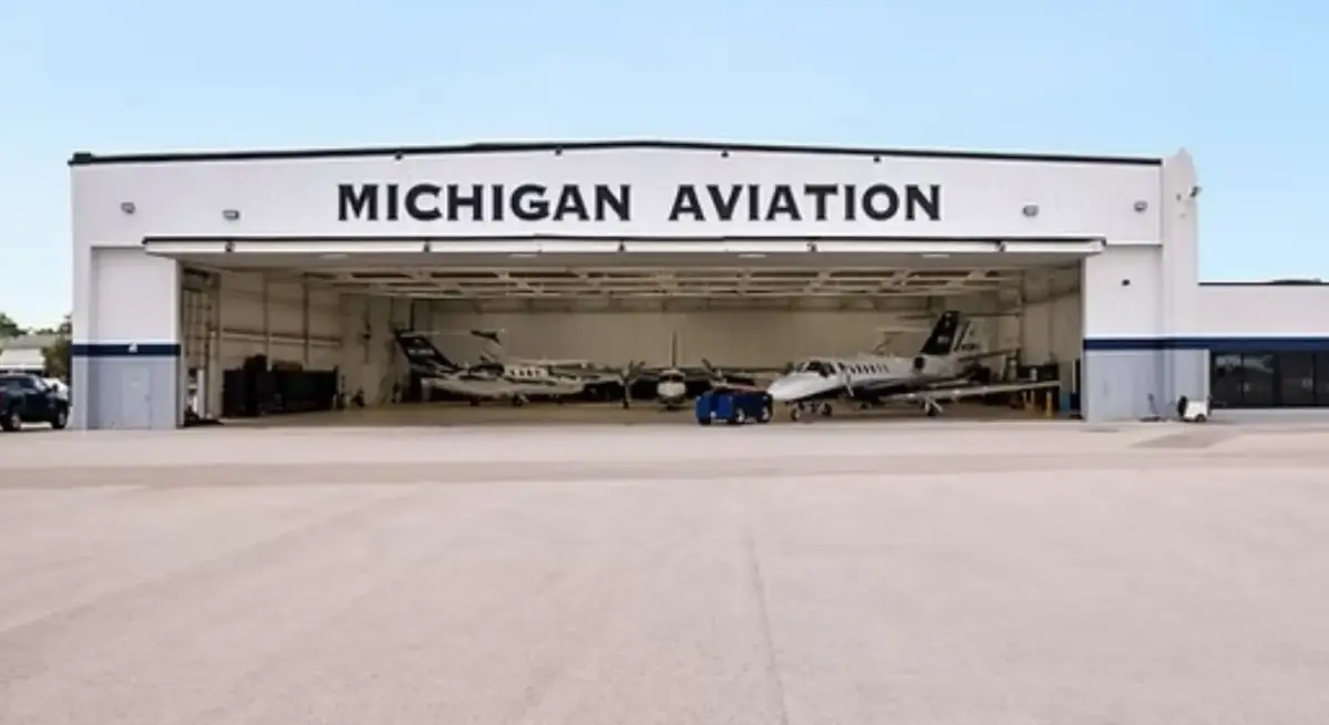 Michigan Aviation FBO hangar with multiple private jets stored inside, supporting premium charter operations at a Phillips 66 Aviation-affiliated facility