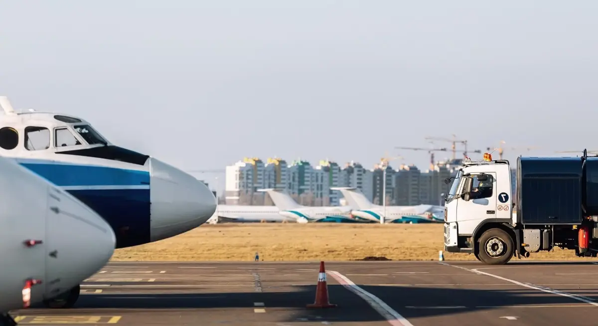 Private jets parked on an FBO tarmac alongside a ground support vehicle