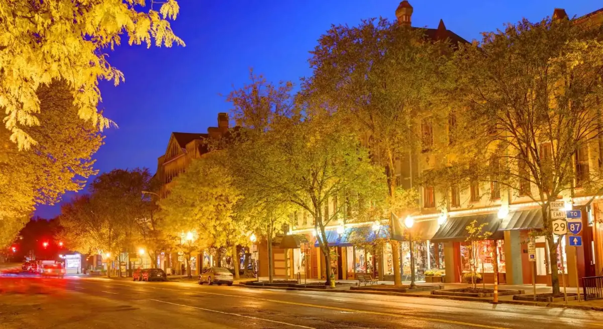 Tree-lined downtown Saratoga Springs street illuminated at night, a premier private jet charter destination in upstate New York